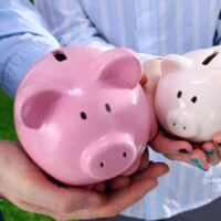 bigstock-Piggy-Bank-in-hands-of-a-famil-104028596.jpg